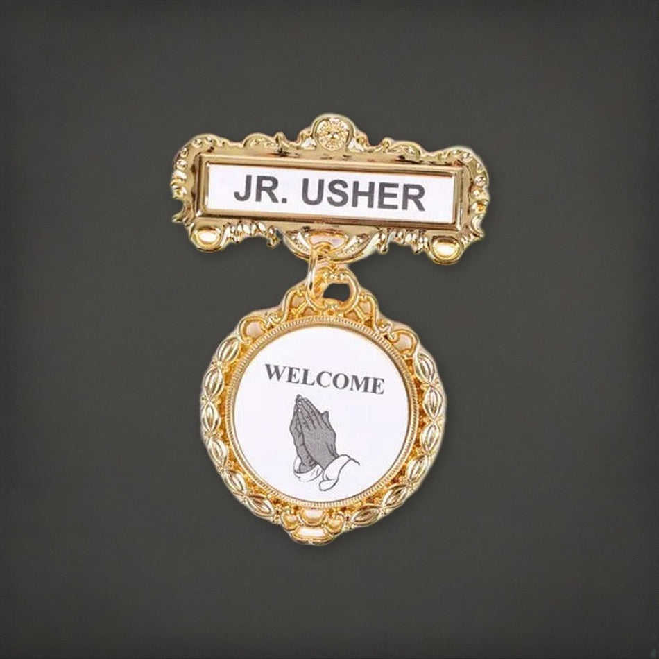 Badge - Fancy Round - Jr Usher - Ethnic Praying Hands - Pin on a charcoal backdrop