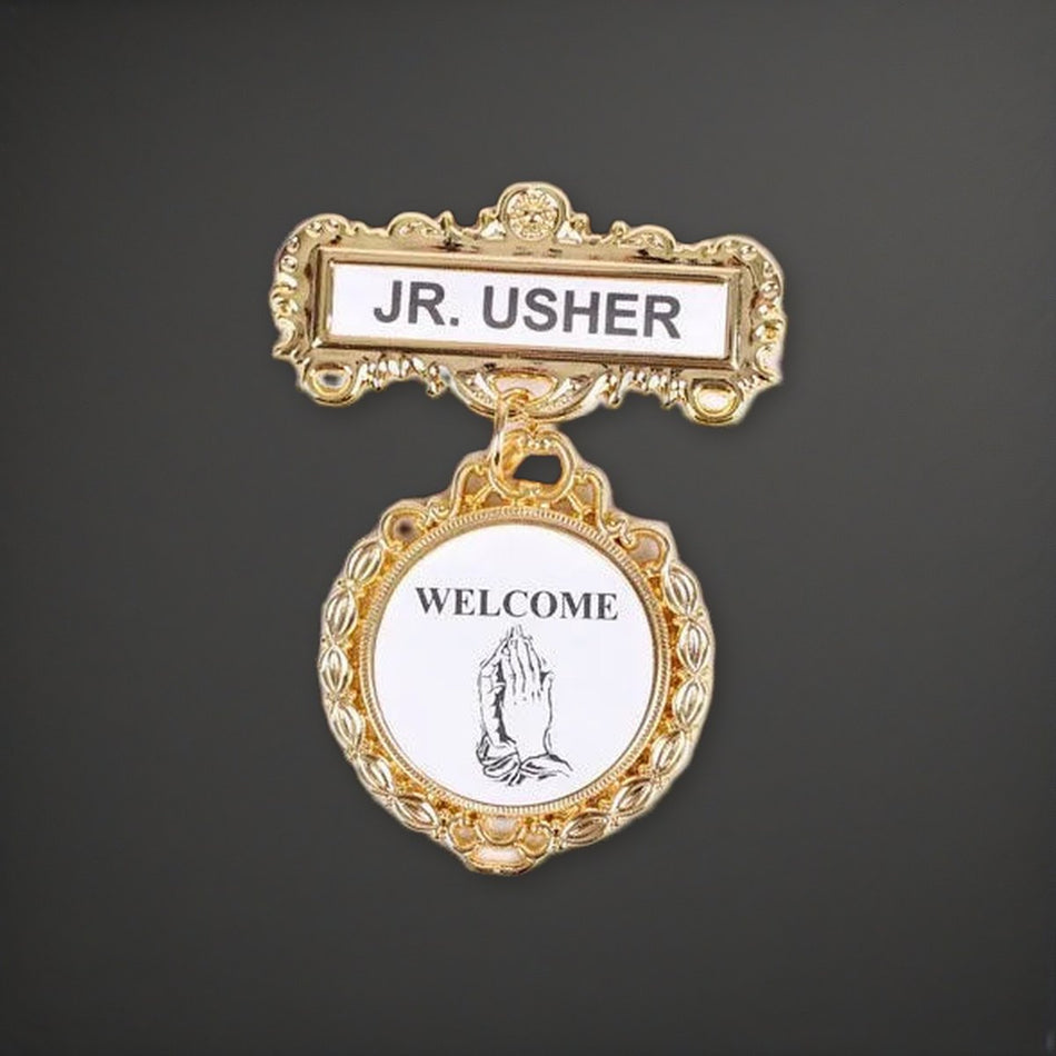Badge - Fancy Round - Jr. Usher - Praying Hands Welcome - Pin on a charcoal backdrop