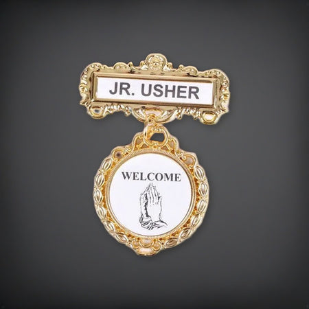 Badge - Fancy Round - Jr. Usher - Praying Hands Welcome - Pin on a charcoal backdrop