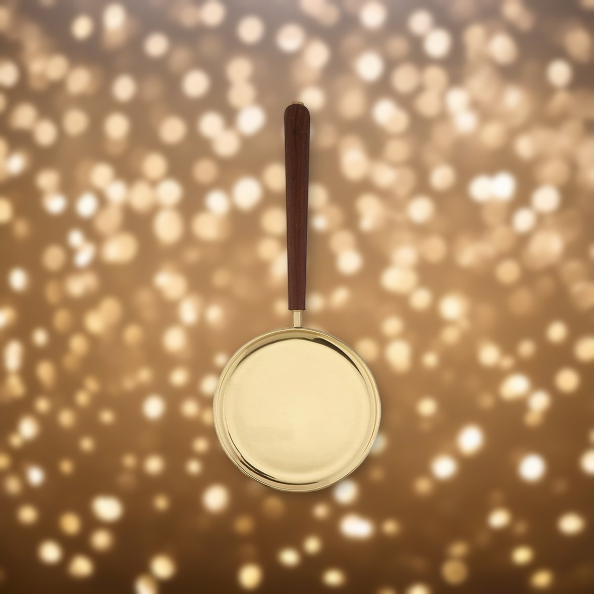 Brass Paten with Straight Handle against soft golden light