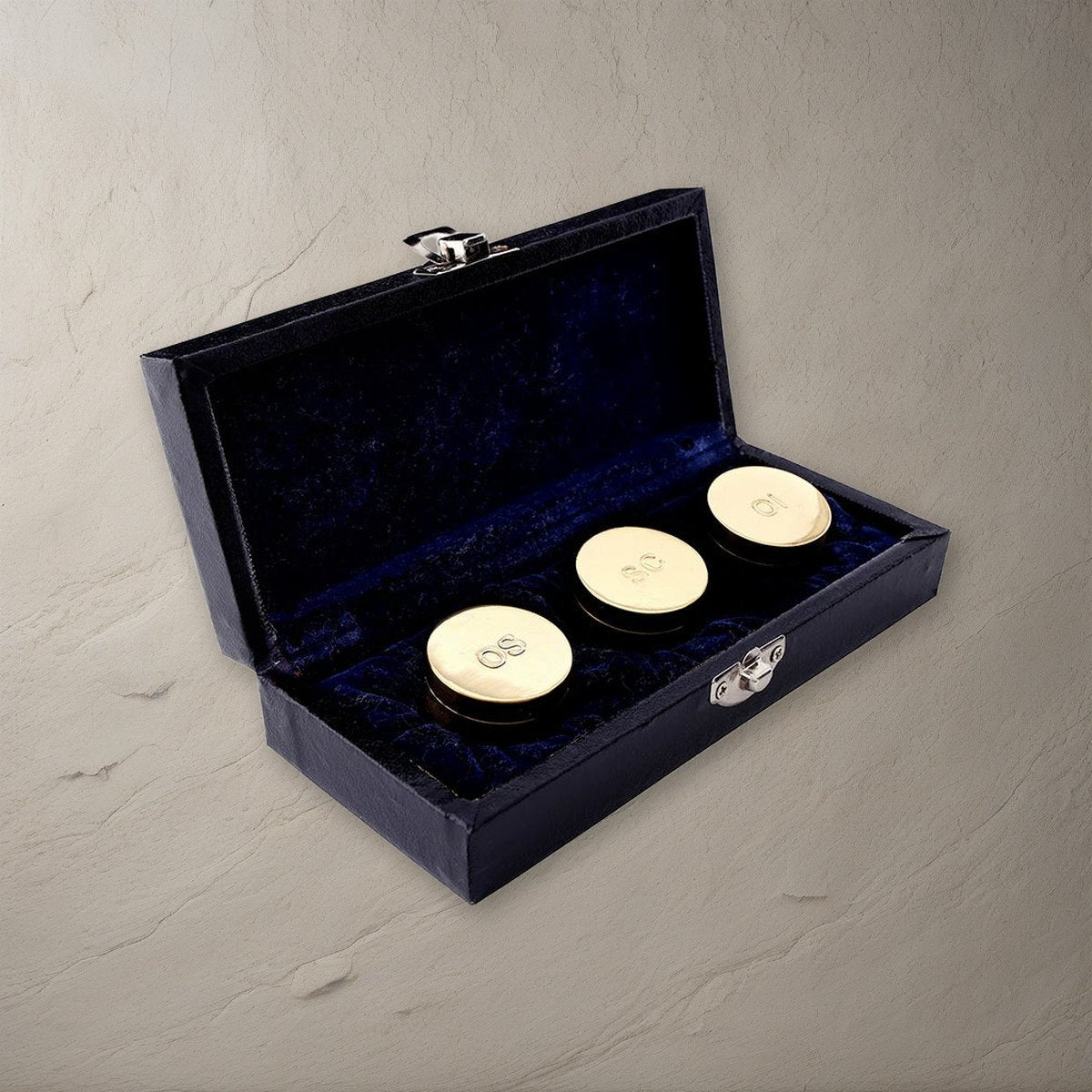 Holy Oil Stock Set of 3 in Case, Polished Brass on a stone background