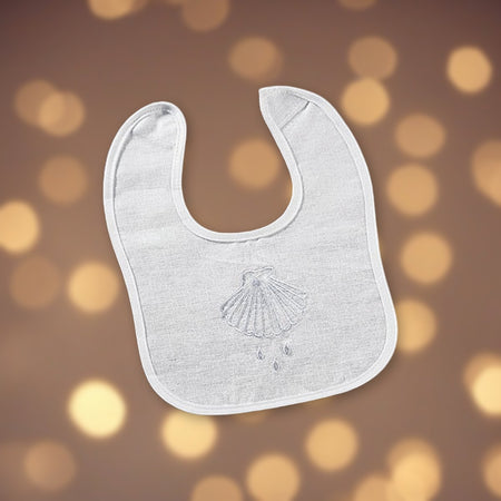 Shell & Water Embroidered Baptismal Bib 12/pk against soft golden light