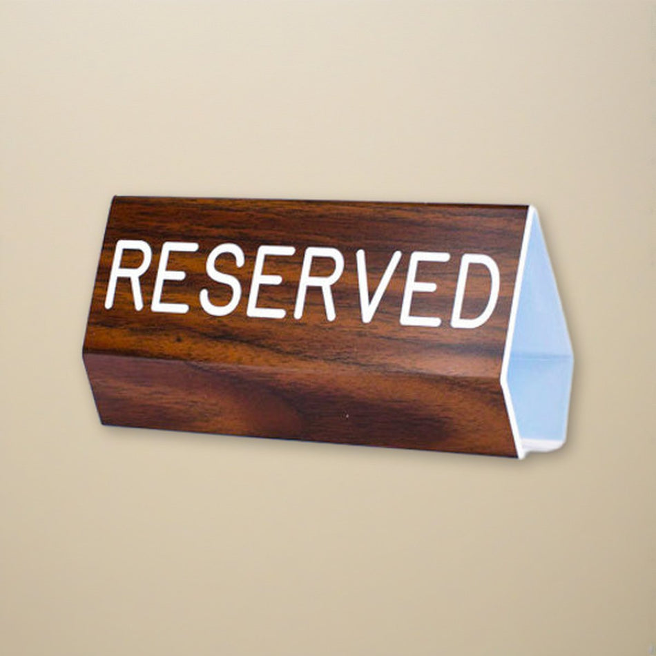 Sign Engraved Pew Reserved Walnut Grain Plastic 3 x 6 on a cream backdrop